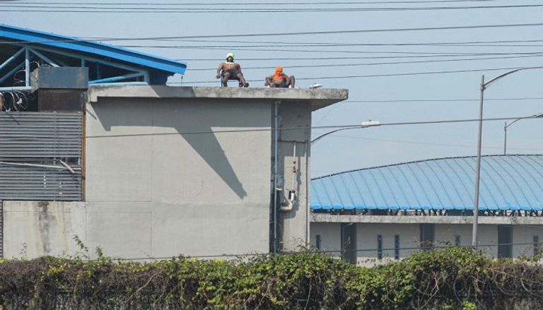 سجناء فوق سطح السجن خلال أعمال الشغب- أ.ف.ب أحد السجناء فوق سطح السجن خلال أعمال الشغب- أ.ف.ب