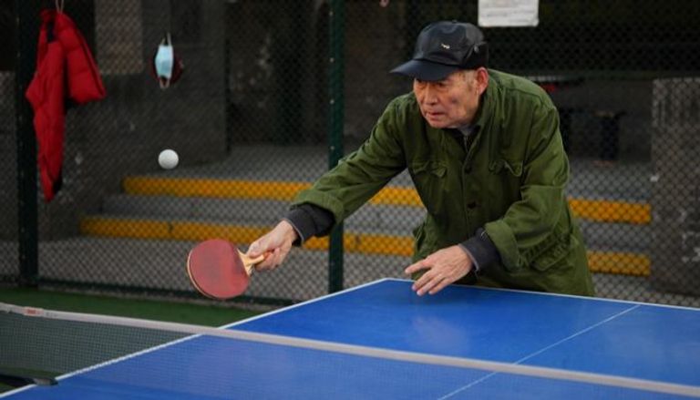 رجل مسن يلعب تنس الطاولة
