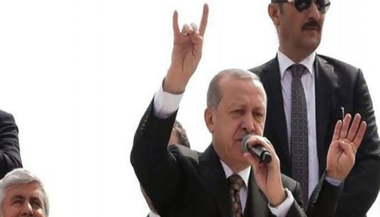أردوغان وهو يلوح بإشارة 