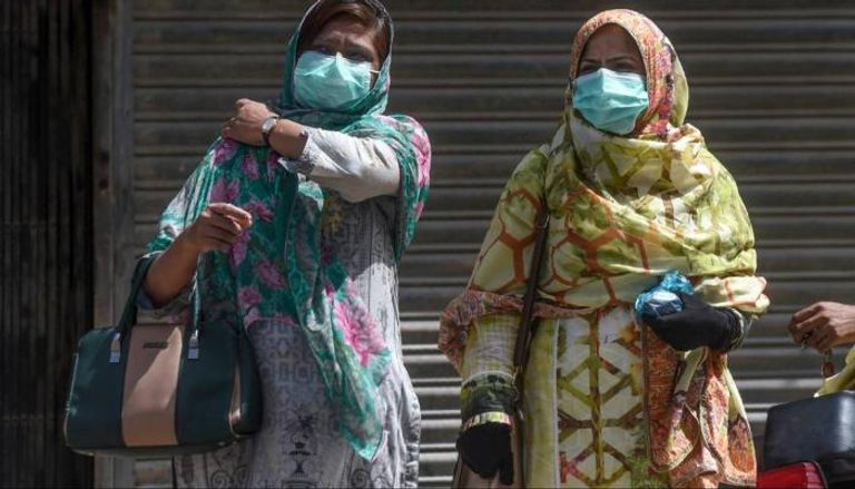 سيدتان ترتديان الكمامة في أحد شوارع باكستان