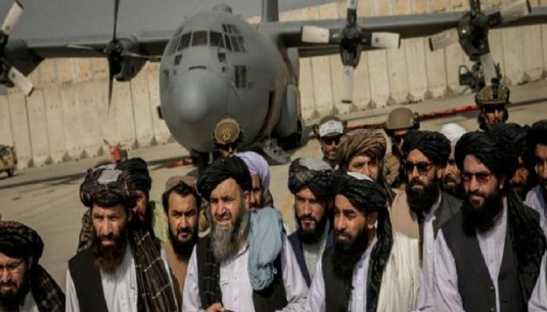 عناصر من طالبان أمام طائرة أمريكية عقب انسحاب واشنطن