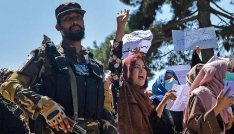 أفغانيات يتظاهرن في كابول وبجانبهن أحد عناصر طالبان (أرشيفية)