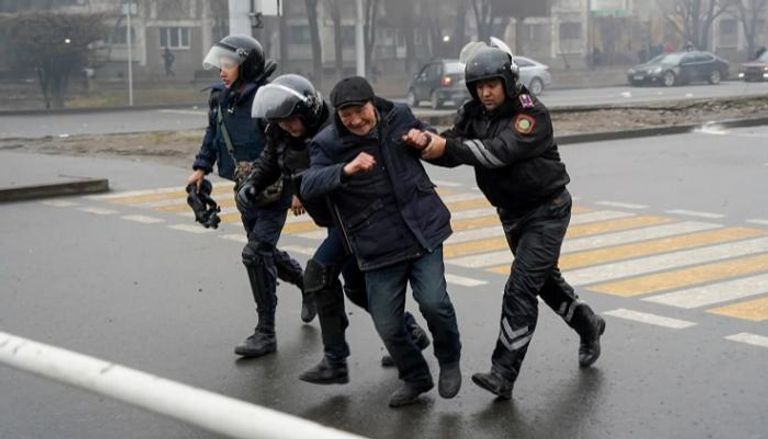 ضباط يعتلقون متظاهرا في كازاخستان - نيويورك تايمز