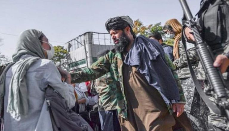 عنصر من طالبان يطالب امرأة بلبس البرقع