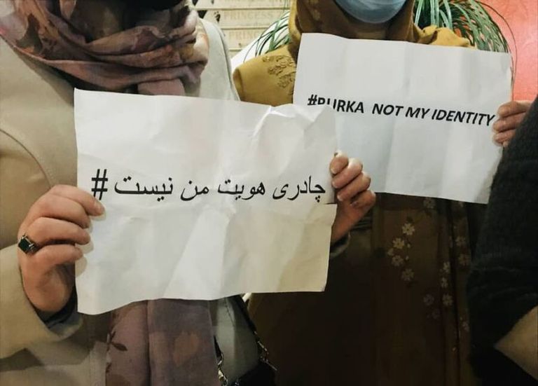 عنصر من طالبان يطالب امرأة بلبس البرقع