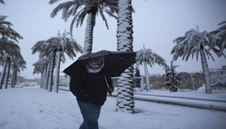 مواطن عراقي يسير وسط تساقط الثلوج - أرشيفية