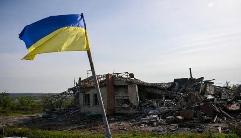 علم أوكراني أمام منزل مدمر بالقرب من إيزيوم بشرق أوكرانيا - أ ف ب