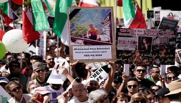 متظاهر بأمريكا يحمل صورة إسكندري الذي قُتل احتجاجا على وفاة مهسا 
