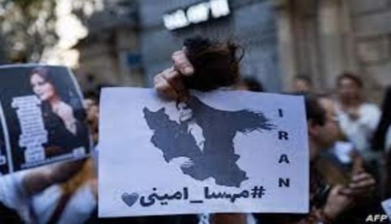 محتجون إيرانيون يرفعون لافتات عليها صورة واسم مهسا أميني