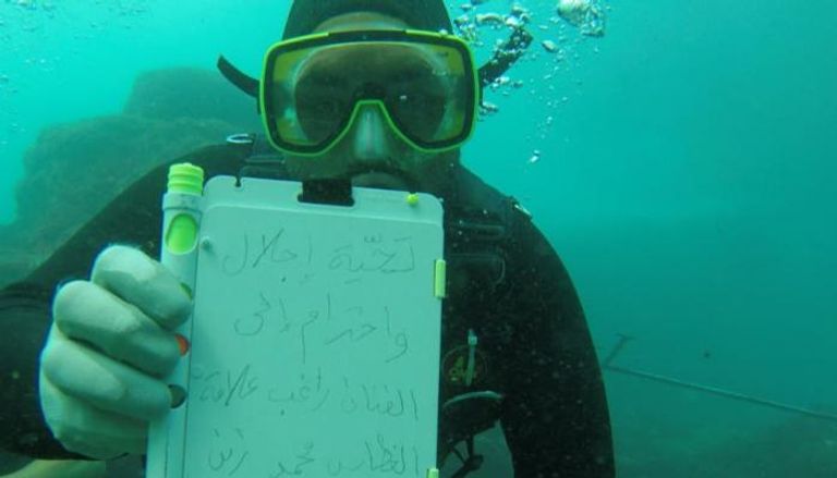الغواص محمد زين حاملًا رسالته إلى راغب علامة تحت الماء