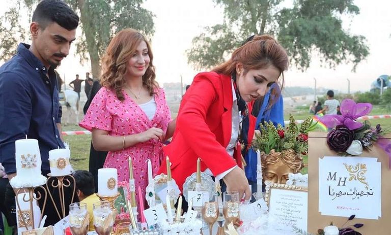 مشاركون في مهرجان بغداد للآكل عند تمثال شهريار ببغداد