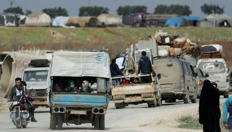 نازحون يستقلون شاحنات مع متعلقاتهم في عفرين السورية