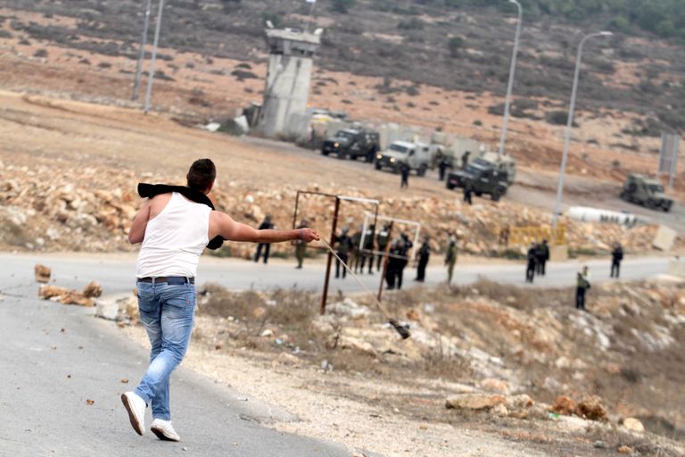 فلسطيني يلقي الحجارة باتجاه جنود إسرائيليين في الضفة - أرشيفية جنود إسرائيليون يبكون عقب مقتل أحد زملائهم في مواجهات - أرشيفية