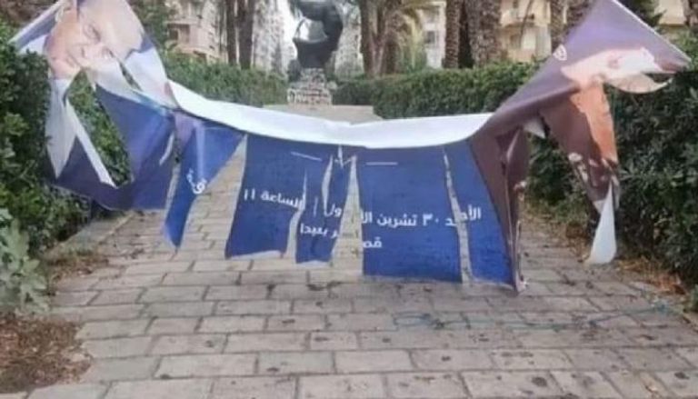 لافتة ممزقة تحمل صورة الرئيس اللبناني السابق ميشال عون