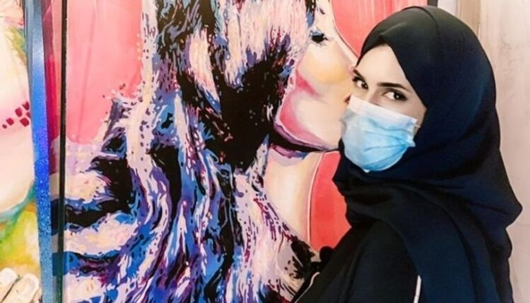 مريم الشملاوي مع إحدى لوحاتها - أرشيفية