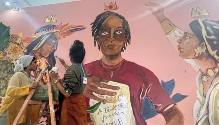 فتاتان ترسمان جدارية لدور المرأة في حل أزمة تغير المناخ