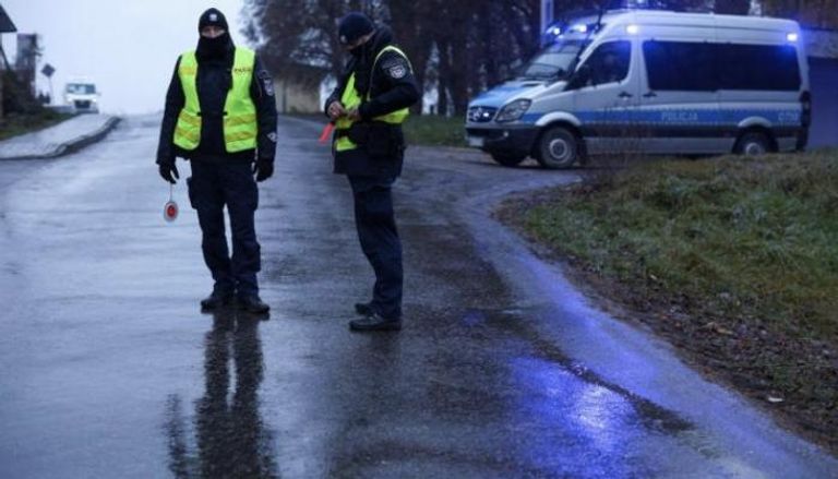 اثنان من عناصر الشرطة البولندية بمحيط موقع سقوط الصاروخ