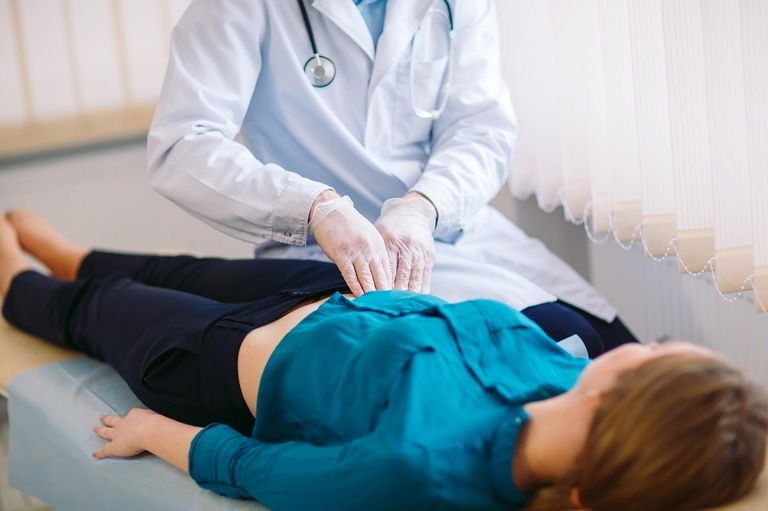 فتاة تشير إلى منطقة الألم في بطنها