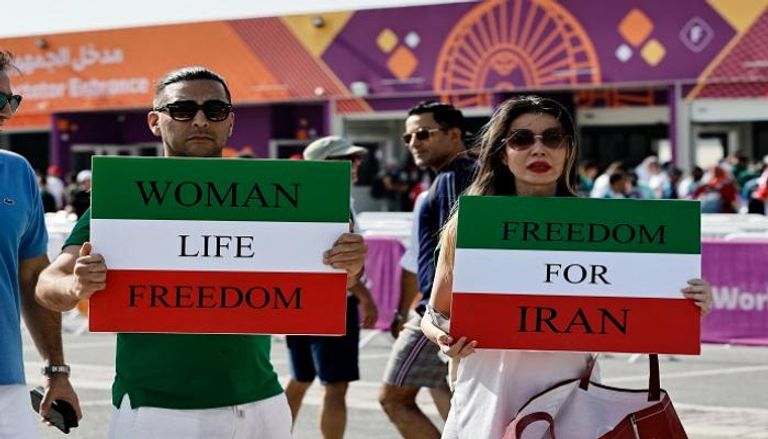مشجعان يرفعان شعار حرية المرأة على أبواب ستاد خليفة الدولي بقطر
