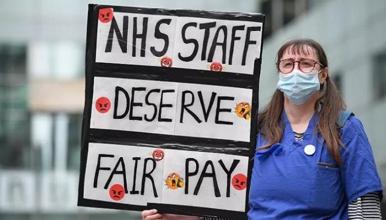ممرضة بريطانية ترفع لافتة تطالب بأجور عادلة