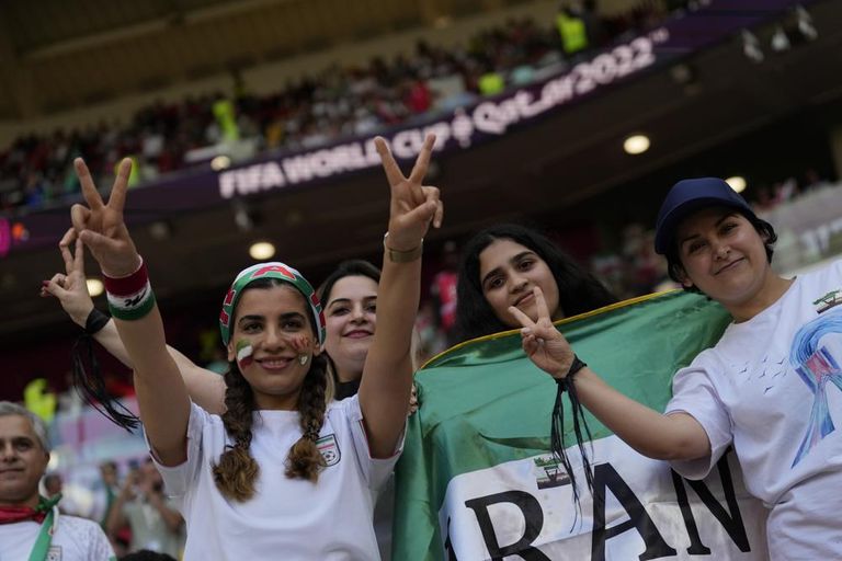 مشجعان داخل استاد أحمد بن علي يحملان لافتة داعمة لاحتجاجات إيران