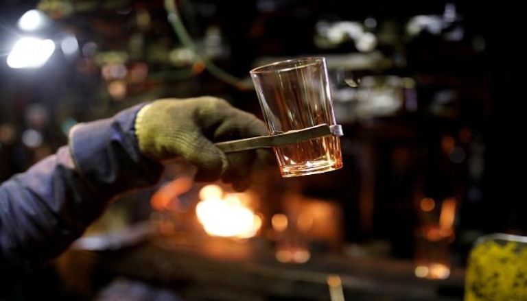 موظف يحمل كأسا في مصنع دورالكس للزجاج - رويترز