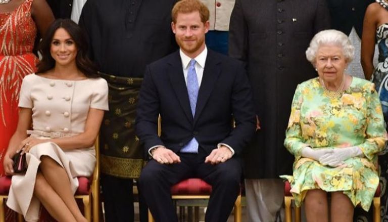 الأمير هاري يتوسط الملكة الراحلة إليزابيث وزوجته ميجان