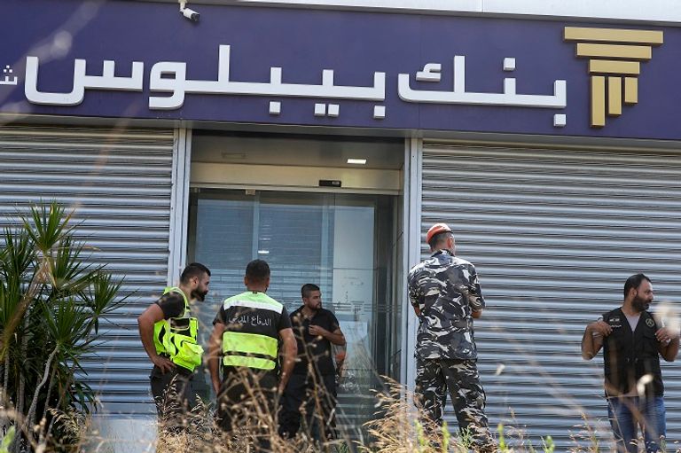 رجال أمن لبنانيون خارج مقر أحد البنوك - أرشيفية مواطنون لبنانيون خارج أحد فروع بنك الاعتماد اللبناني - أرشيفية
