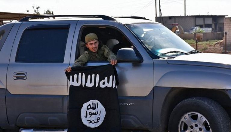 أحد عناصر داعش يحمل راية التنظيم - أرشيفية