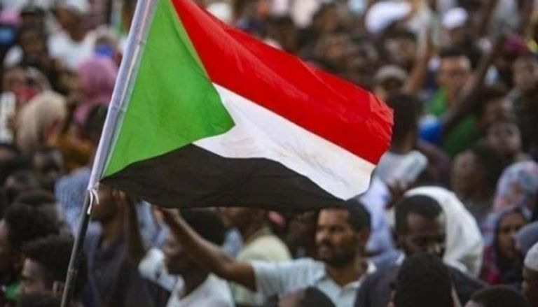 متظاهر يحمل علم السودان خلال فعالية احتجاجية - أرشيفية