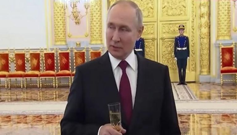 الرئيس الروسي فلاديمير بوتين ممسكا بكأس شمبانيا - تليجراف