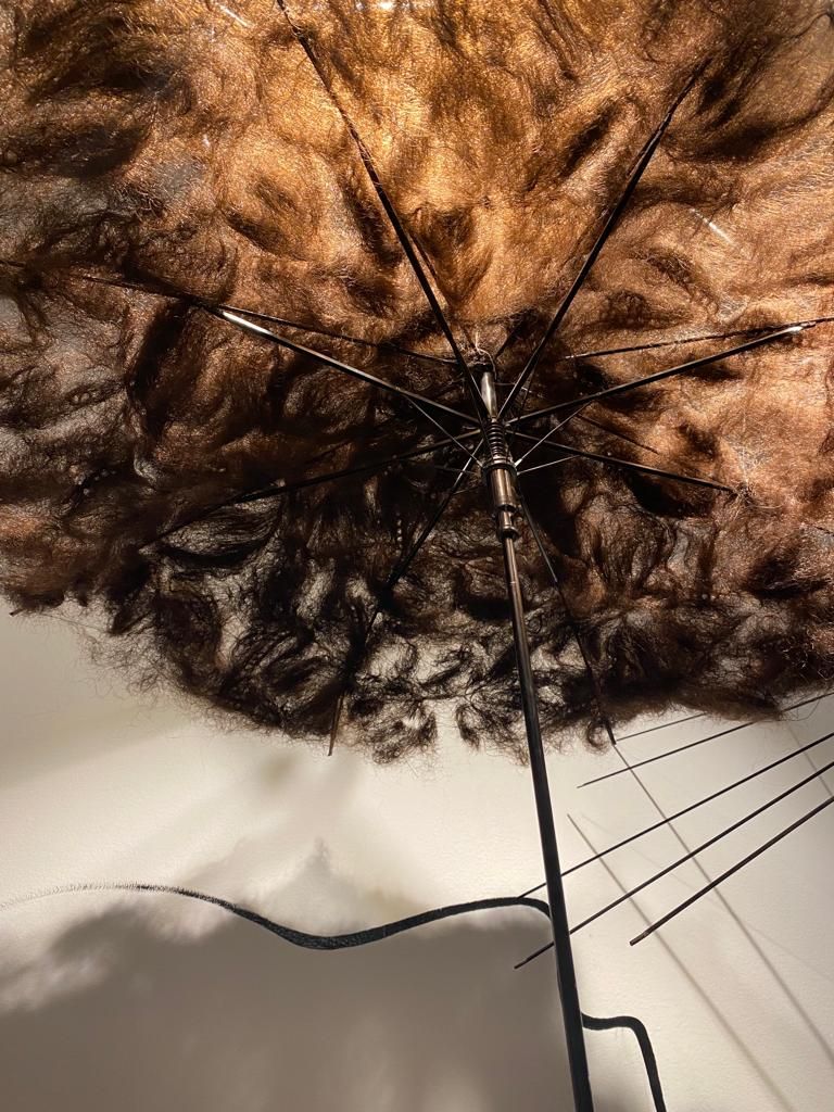 المظلة مكسوة بشعر الفنانة ماجي الشاويش المتساقط