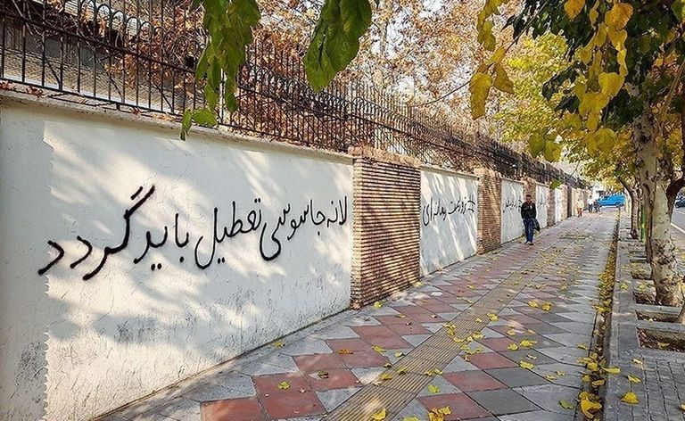 موظفون دبلوماسيون يزيلون شعارات معادية لبريطانيا من جدران سفارتها بطهران