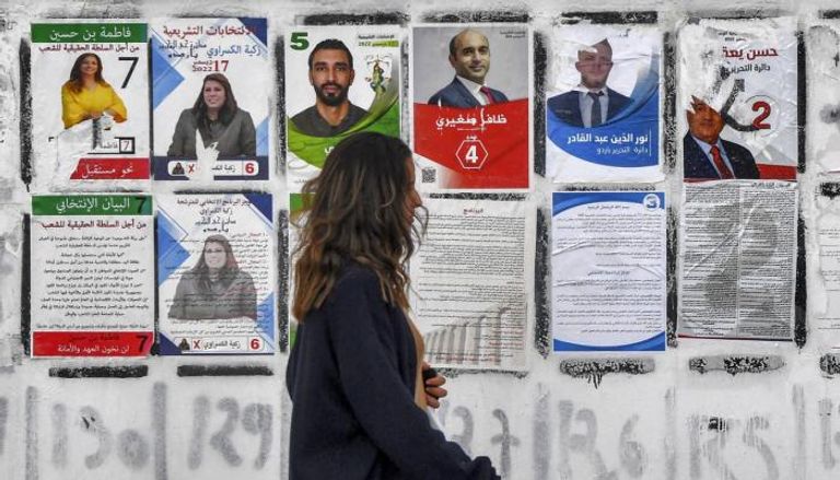 فتاة تونسية أمام ملصقات انتخابية (أ ف ب)