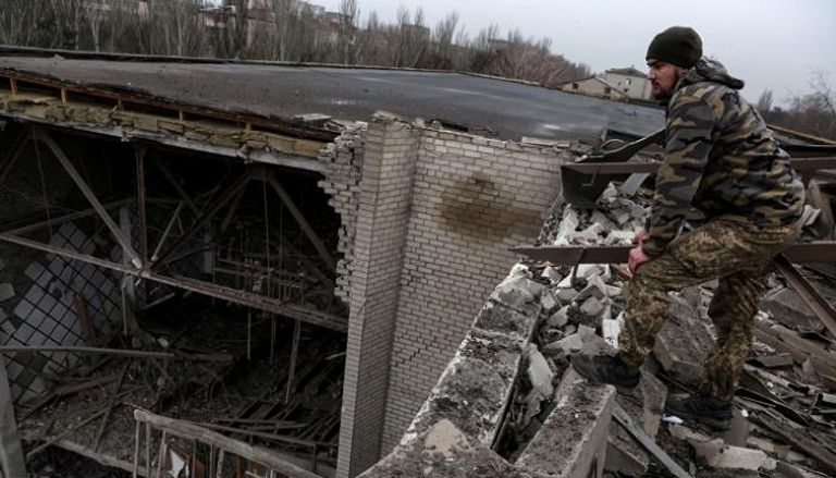 جندي أوكراني يشاهد أثار القصف الروسي