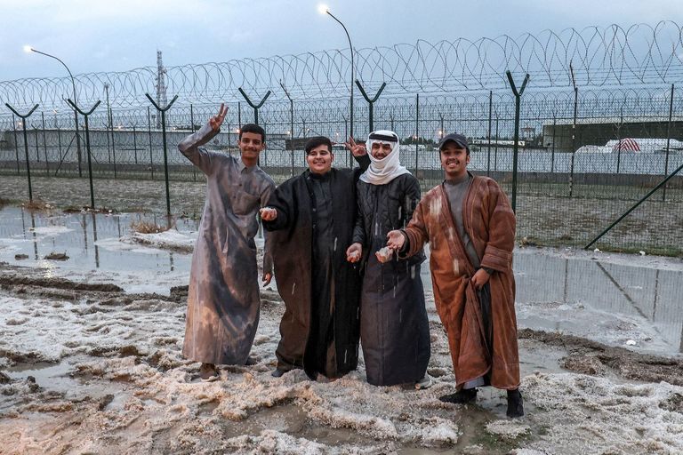 رجال يبتهجون بسبب الثلوج التي تساقطت على مناطق في جنوب الكويت الثلوج تتساقط في الكويت