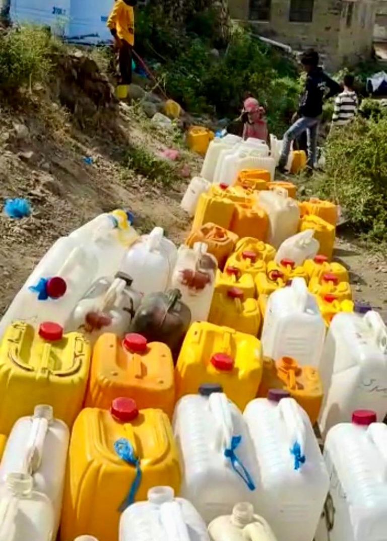 نساء وفتيات يقفن في طابور طويل للحصول على المياه