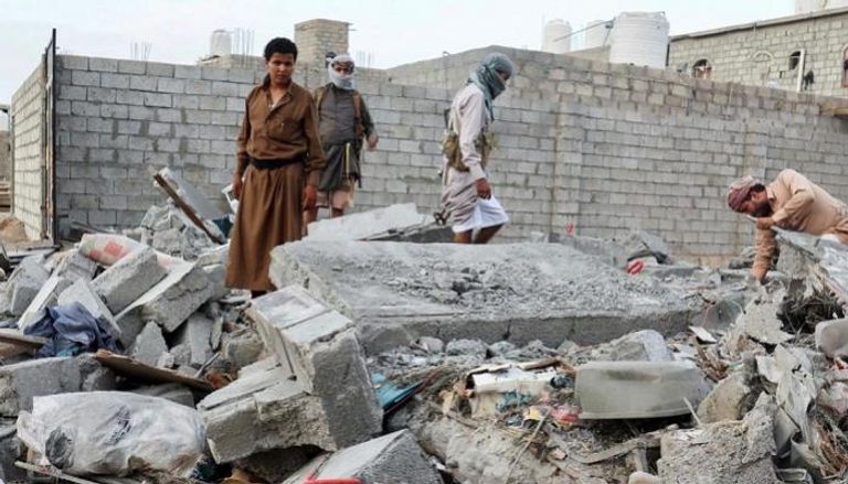 يمنيون على أطلال منزل قصفه الحوثيون.. أرشيفية