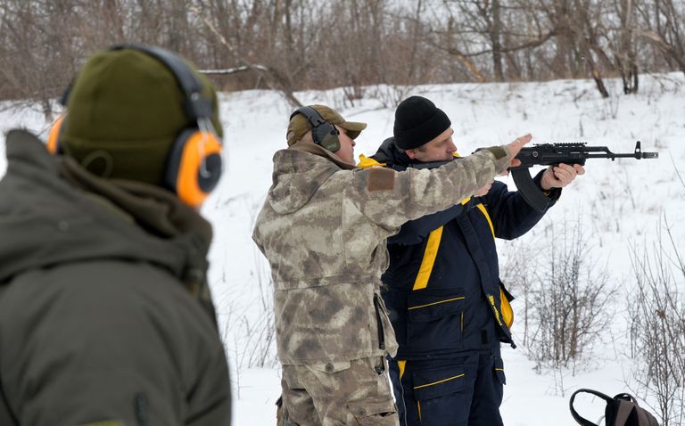 عسكري أوكراني يدرب فتاة مدنية على ضرب النار