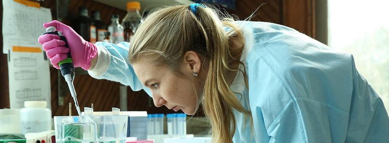 باحثة تستخدم المجهر