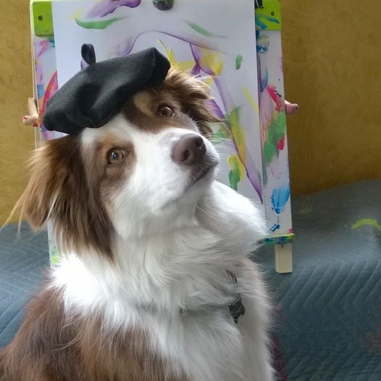 الكلبة إيفي بجوار إحدى لوحاتها الفنية