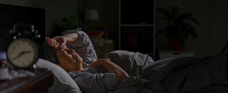 شخص ينظر إلى هاتفه قبل النوم- أرشيفية