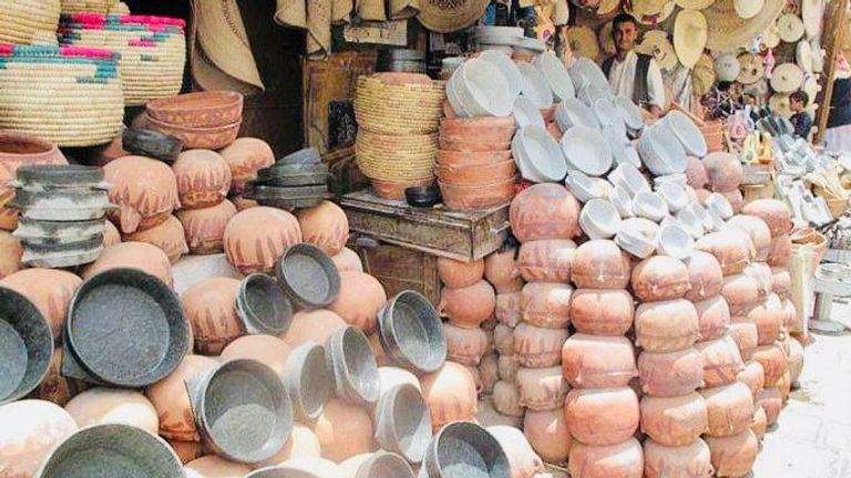 حرفي ينقل أواني فخارية داخل المصنع الوحيد المتبقي في حيس اليمنية