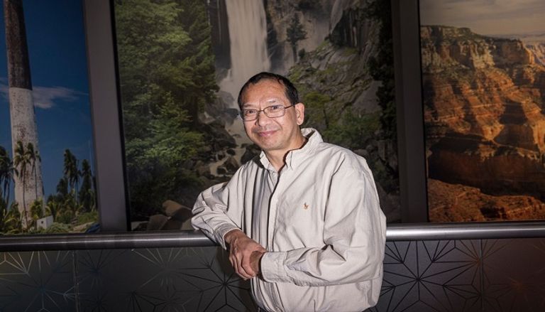 كيو تي لونغ وخلفه مجموعة من صوره