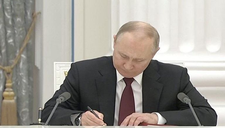 الرئيس الروسي خلال التوقيع على مرسوم الاعتراف بدونيتسك ولوهانسك
