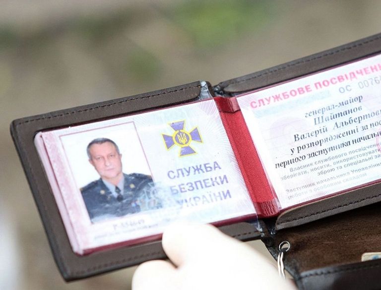 صورة نشرها جهاز الأمن الأوكراني وثيقة تخص الميجور جنرال فاليري شيتانوف بعد اعتقاله في عام 2020. جندي أوكراني أمام جدارية تذكارية لضحايا الحرب منذ 2014