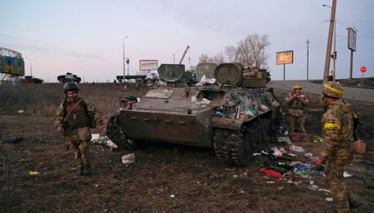 جنود أوكرانيون بجوار مدرعة روسية