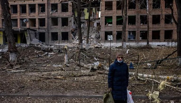 سيدة تقف أمام إحدى البنايات المدمرة في فاسيلكيف - الجارديان