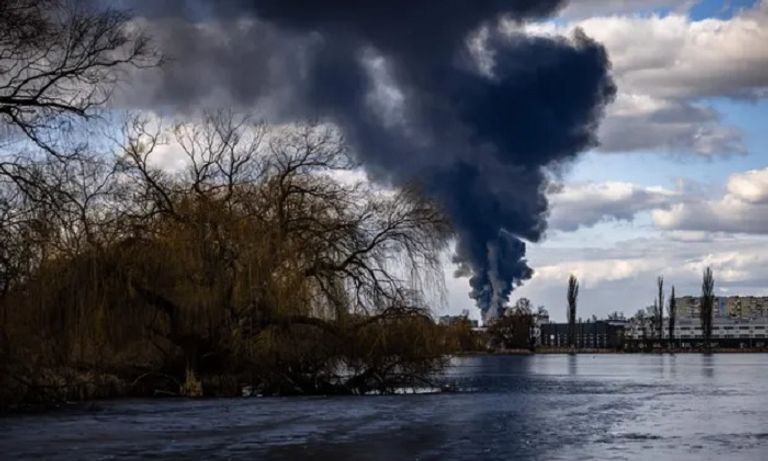 سيدة تقف أمام إحدى البنايات المدمرة في فاسيلكيف - الجارديان