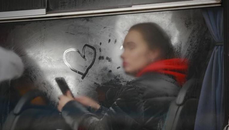 إحدى الأوكرانيات رسمت قلبا على حافلة متوجهة إلى خارج البلاد